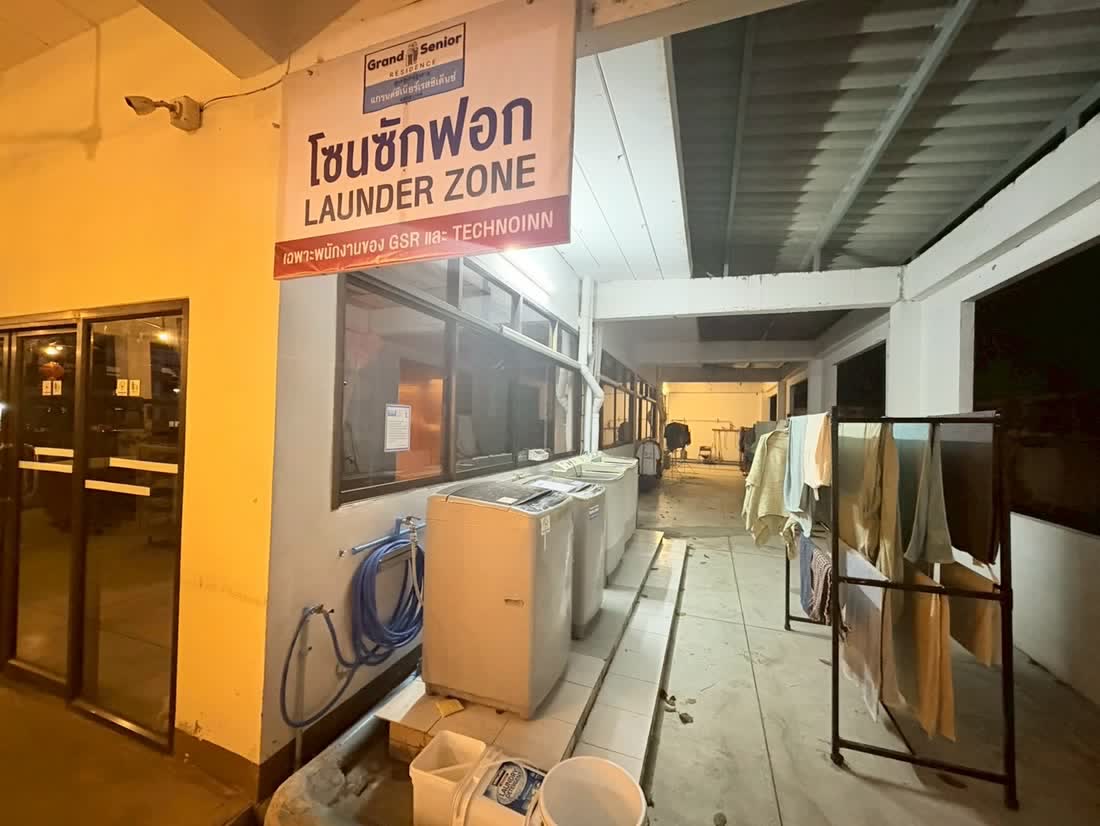 โซนซักฟอกของศูนย์ ป้ายโซนซักฟอก LAUNDER ZONE เครื่องซักผ้าเรียงตามแนวผนัง และราวตากผ้า