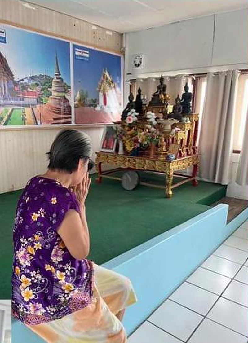 ผู้สูงอายุนั่งไหว้พระในห้องพระของศูนย์